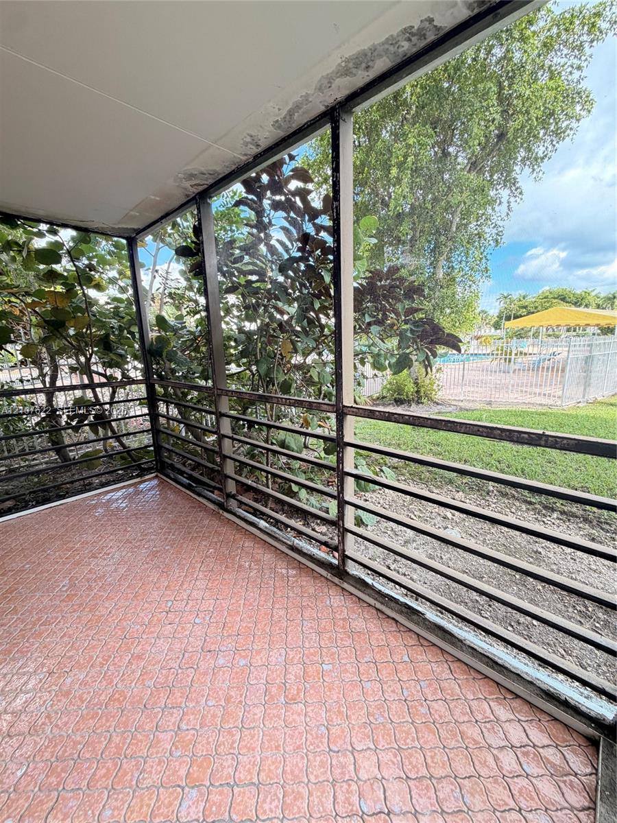 Screened-in porch featuring patterned tile flooring and a metal frame enclosure