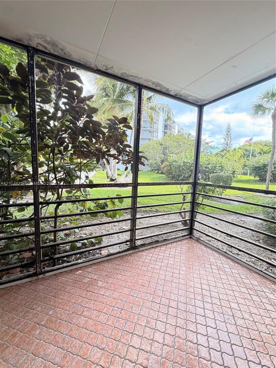 Enclosed screened patio featuring terra cotta tile flooring and dark metal framing