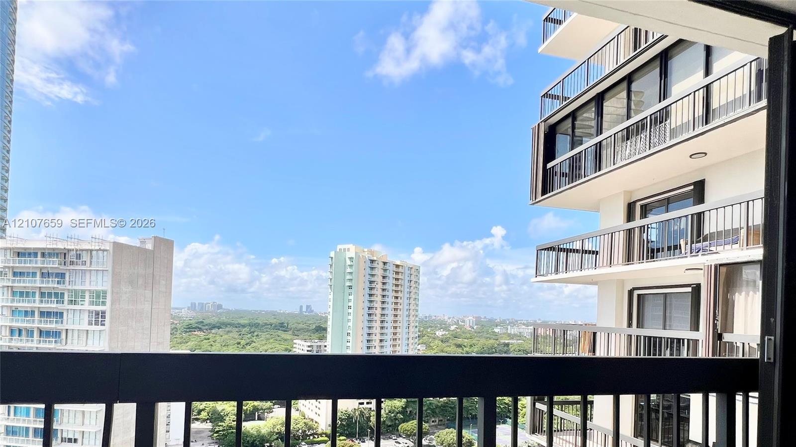 Private balcony featuring black metal railings and panoramic cityscape scenery