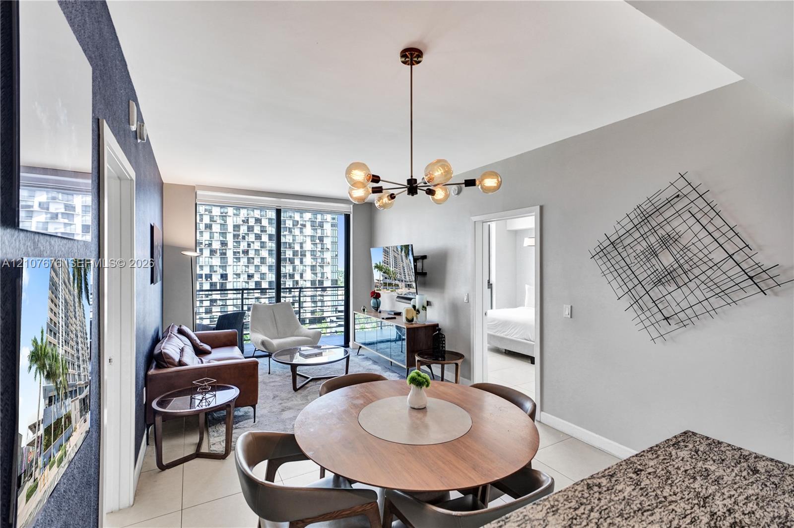 Floor-to-ceiling windows, open-concept layout, modern multi-arm chandelier, and neutral tile flooring