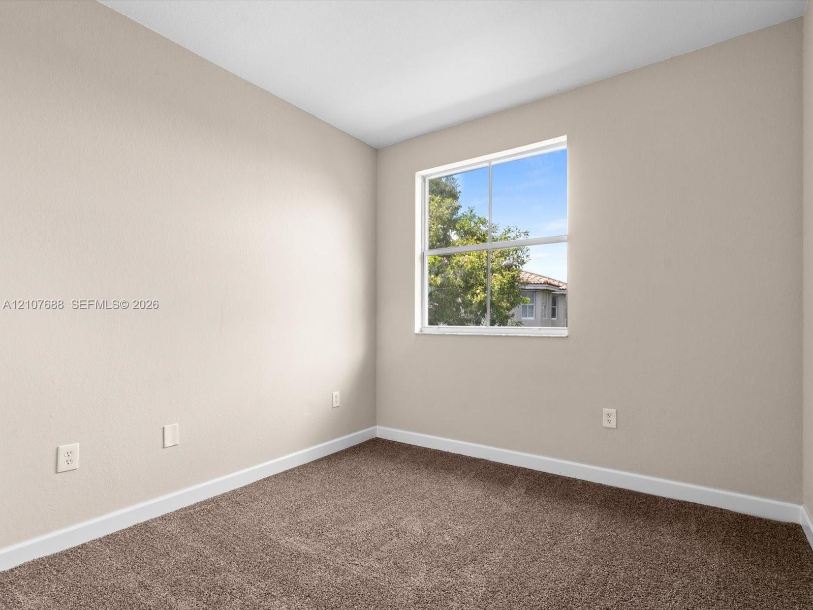 Neutral-toned wall finish, wall-to-wall carpeting, and a single-pane window with natural exterior exposure