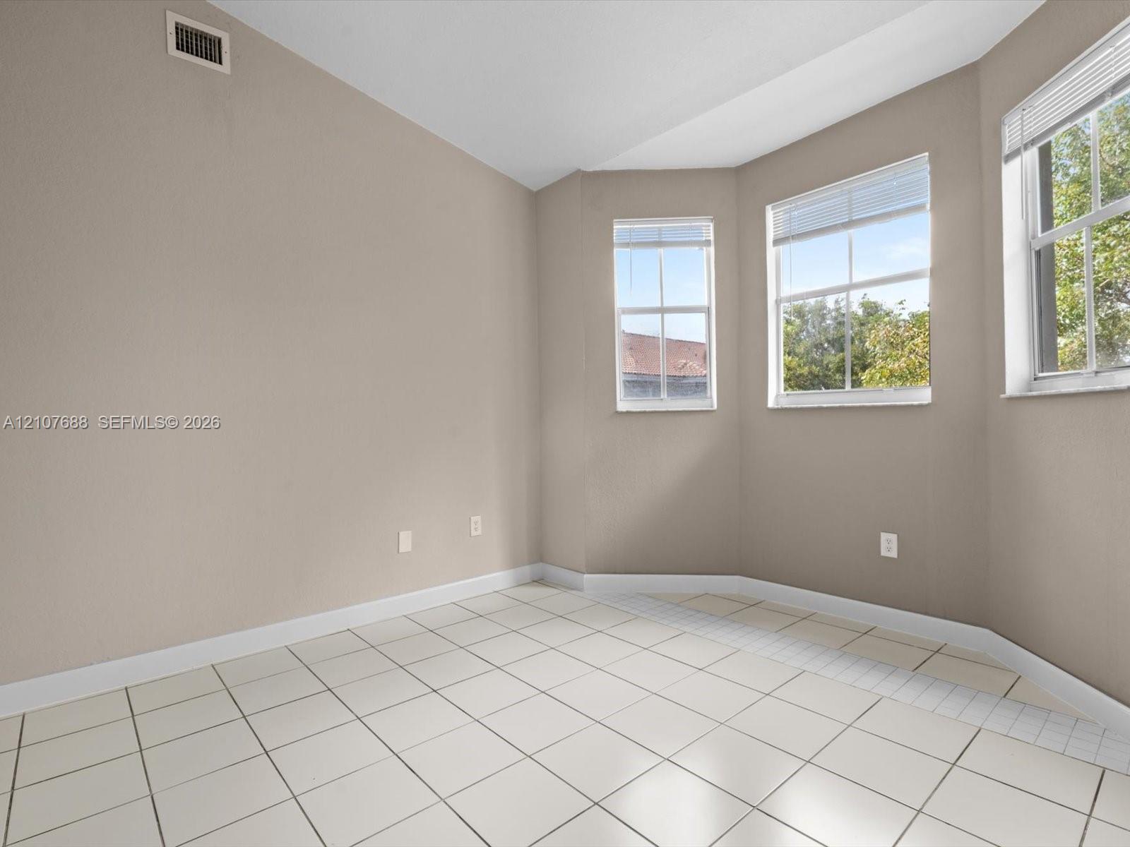 Bay window featuring multi-pane glass windows, neutral wall paint, and ceramic tile flooring