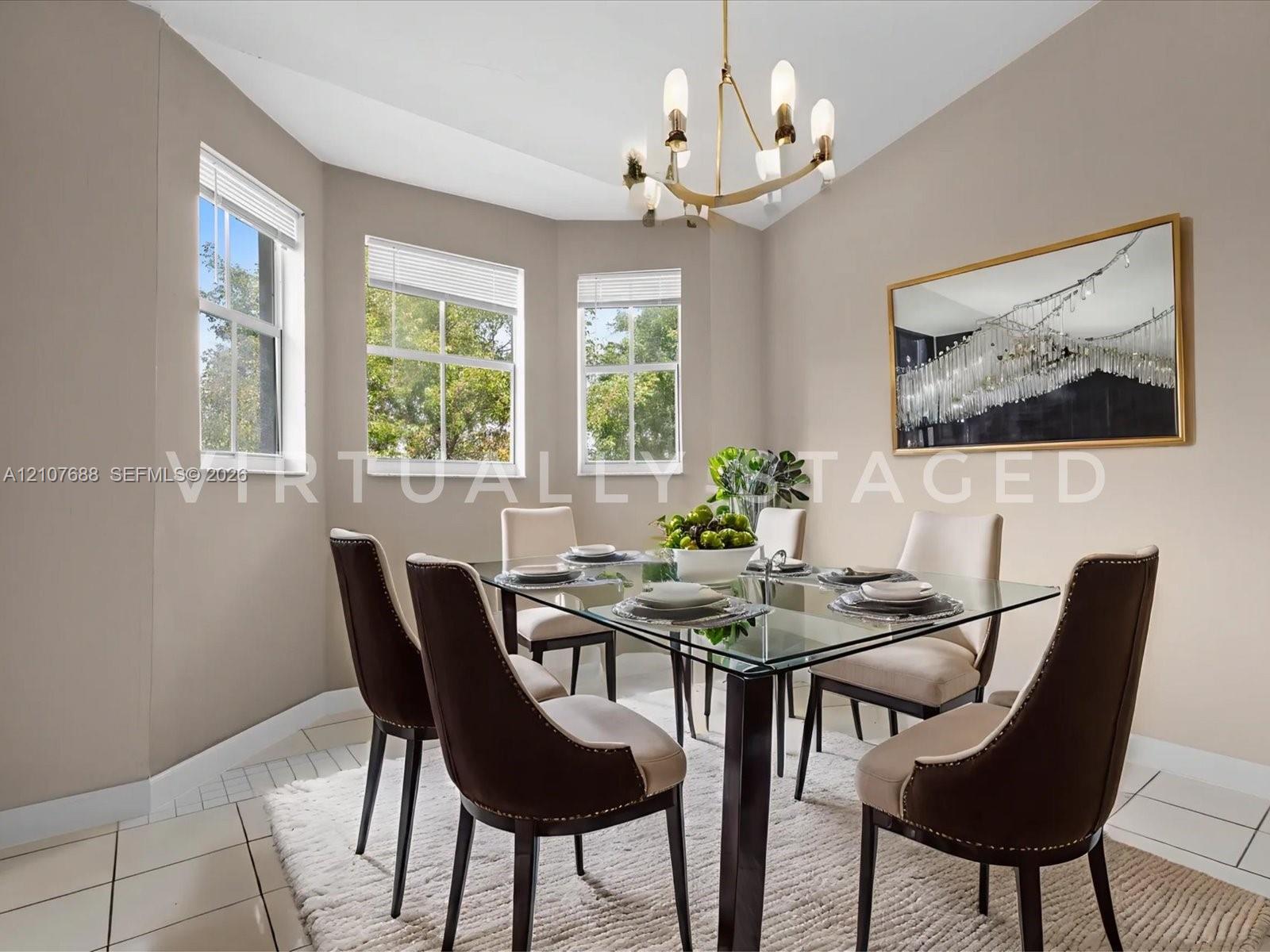 Bay window featuring three large windows, neutral-toned walls, tile flooring, and an elevated metal chandelier with frosted glass shades