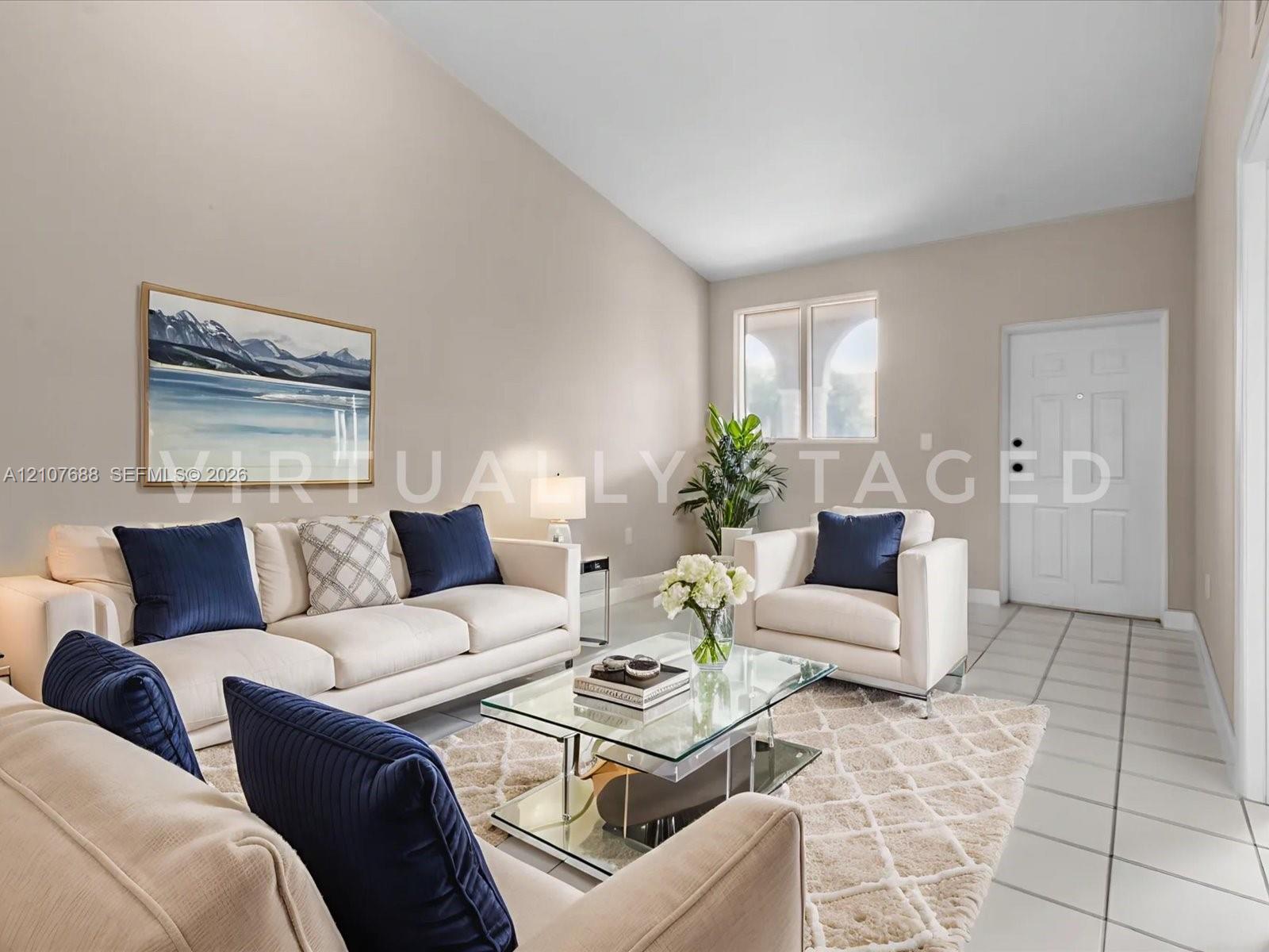 Vaulted ceilings, neutral wall palette, ceramic tile flooring, and multi-pane window with arched architectural detail