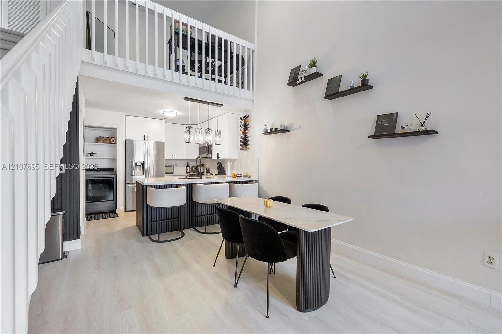 Double-height living area featuring a wood-finish staircase
