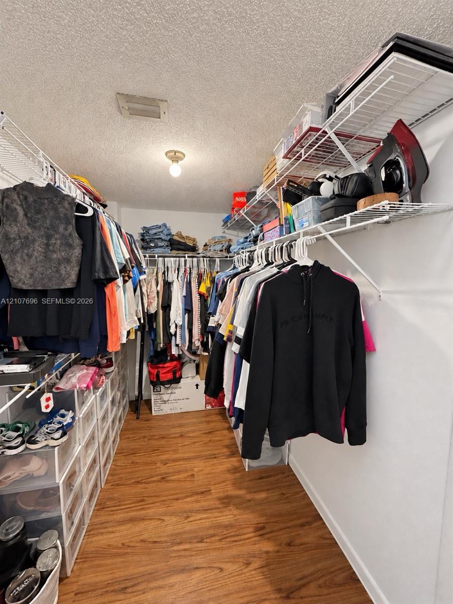 Storage space featuring wood-finish flooring and tiered wire shelving