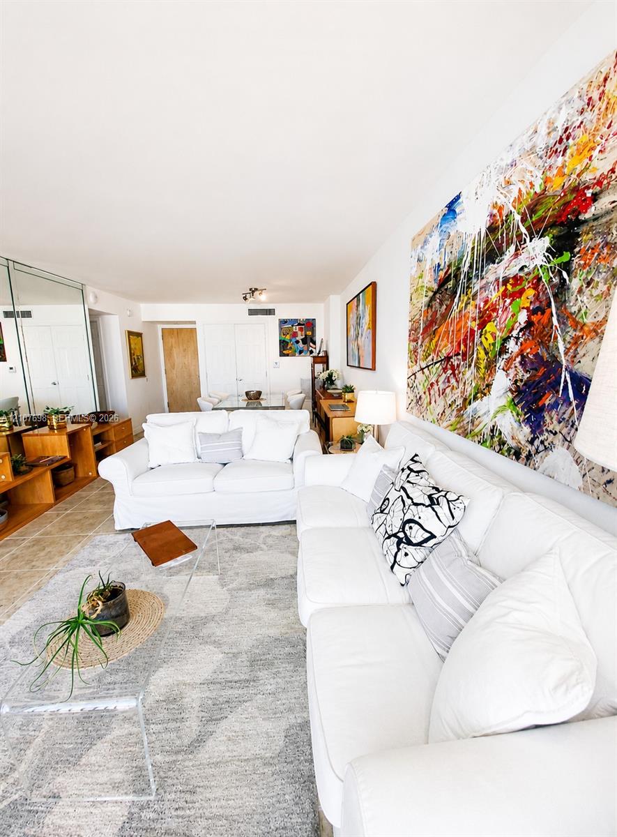 Neutral tile flooring, expansive mirrored wall panels, and white solid-core interior doors
