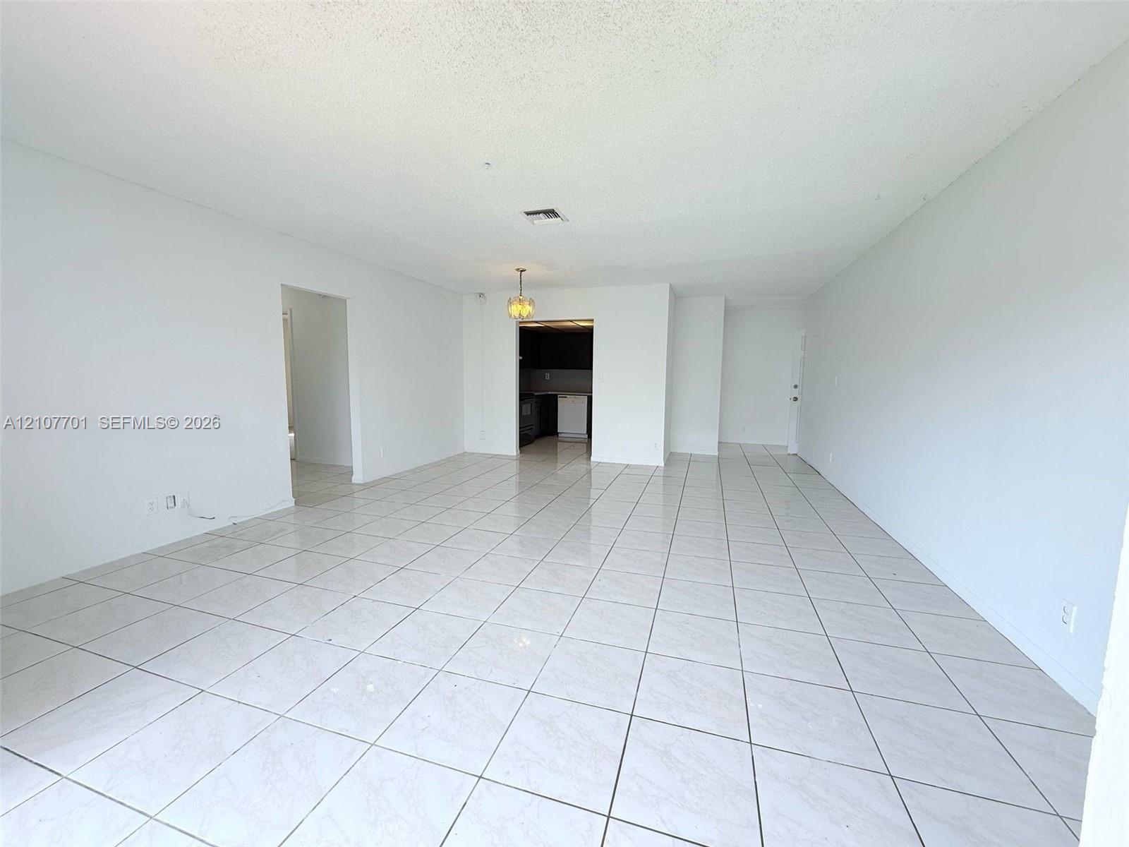 Open-concept floor plan featuring ceramic tile flooring, neutral wall tones, and overhead lighting fixtures