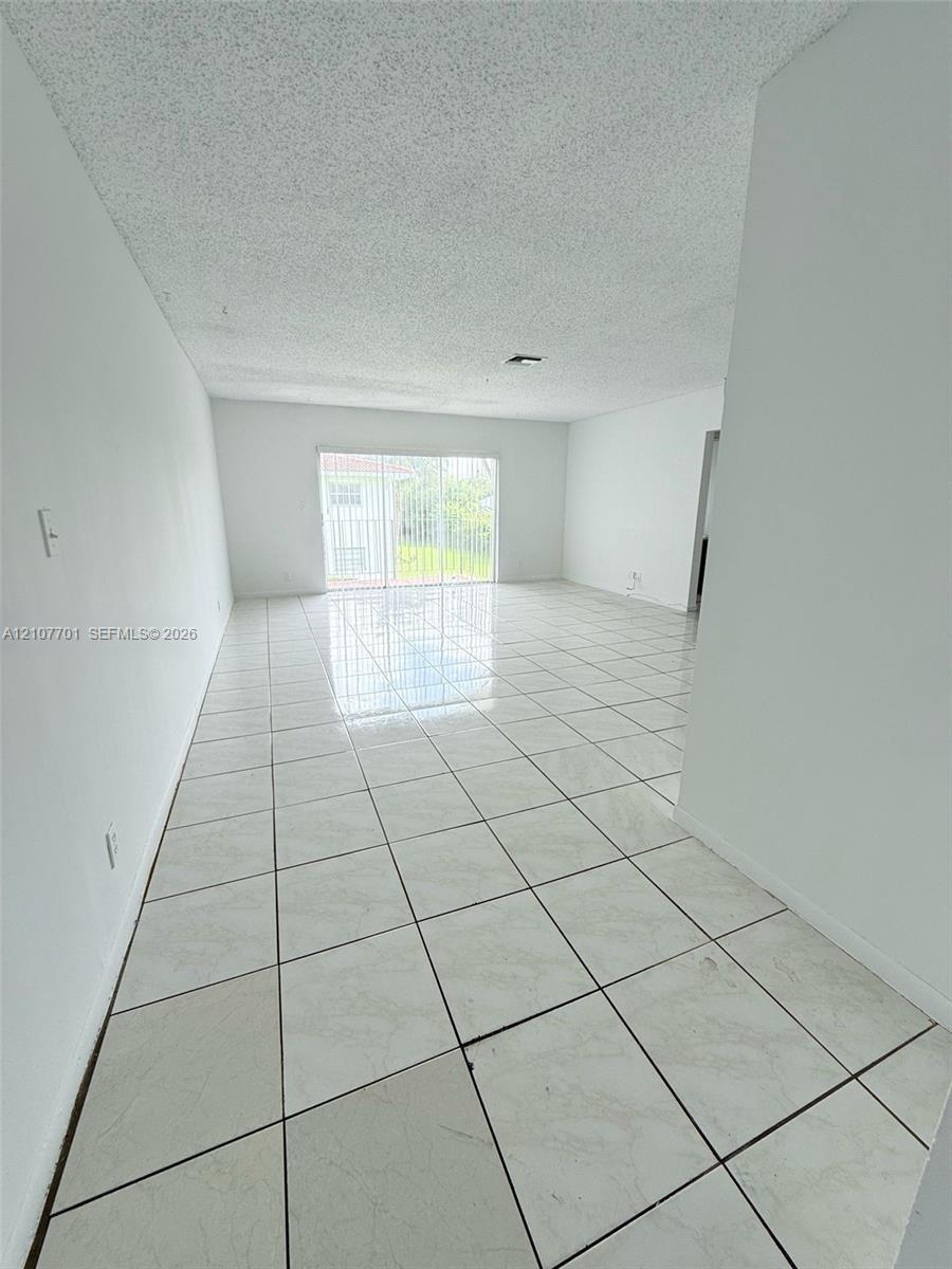 Open-concept interior featuring large-format tile flooring and sliding glass doors Open-concept interior featuring large-format tile flooring and sliding glass doors