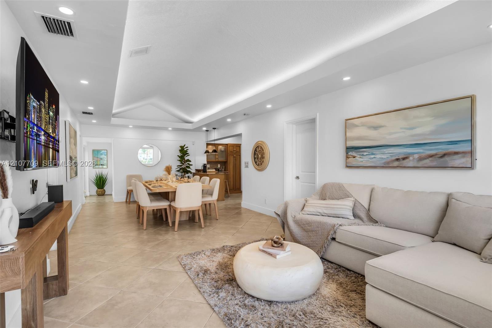Tray ceiling with recessed lighting, tile flooring, and neutral wall tones