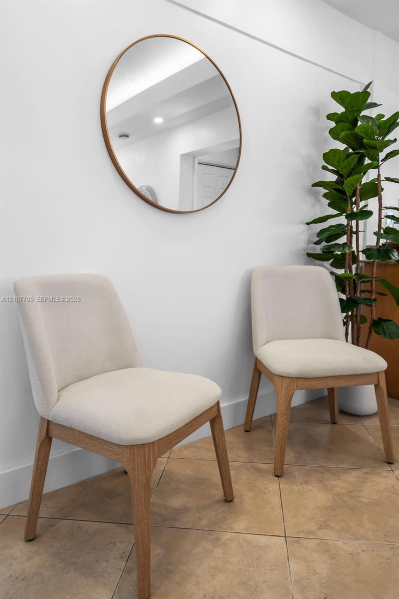 Round wall-mounted mirror with a metallic frame above square-tile flooring
