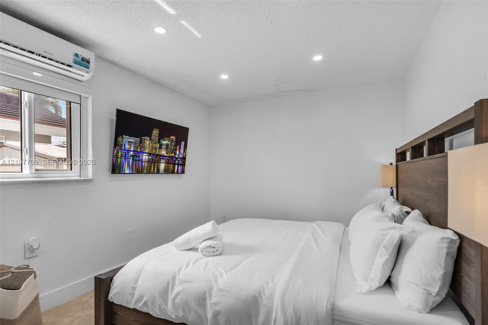 Wall-mounted ductless air conditioning unit, recessed ceiling lighting, and double-pane window