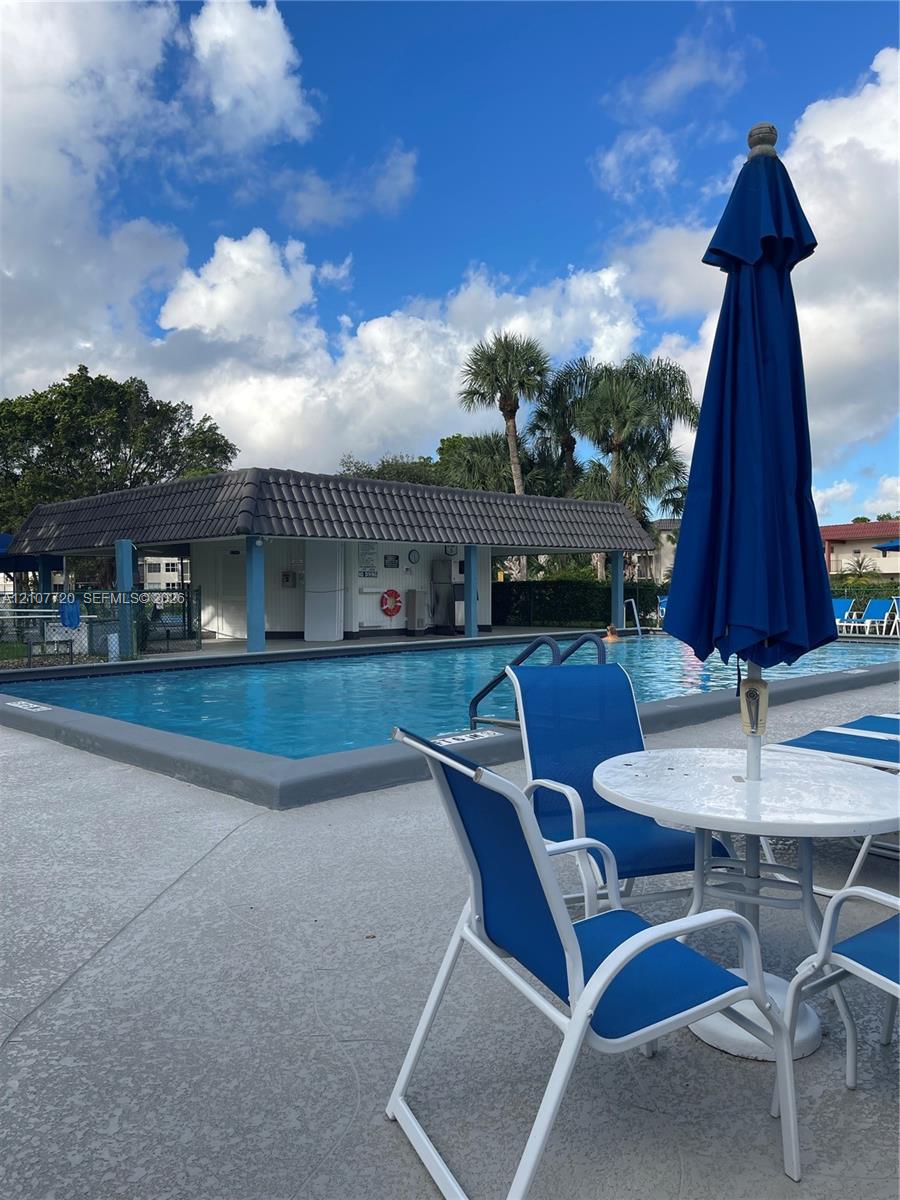 Outdoor swimming pool featuring a concrete deck and a covered pavilion with a tiled roof (more than 6 pool in the community)