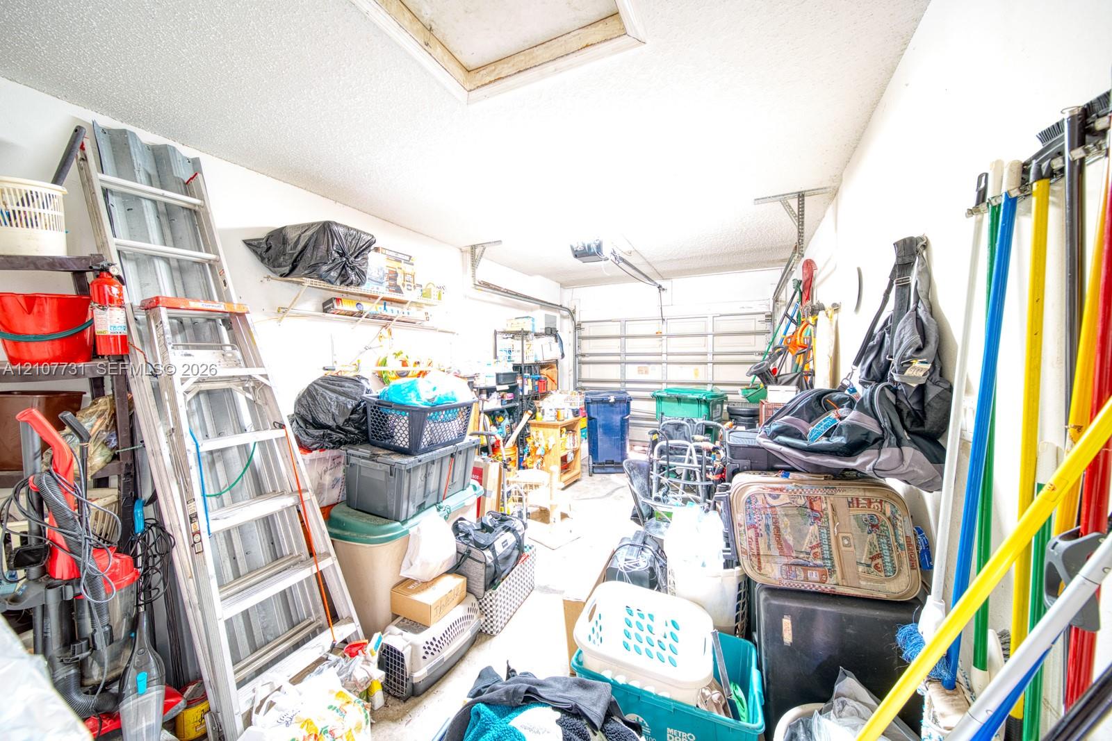Enclosed garage featuring a sectional overhead door and mounted wall shelving
