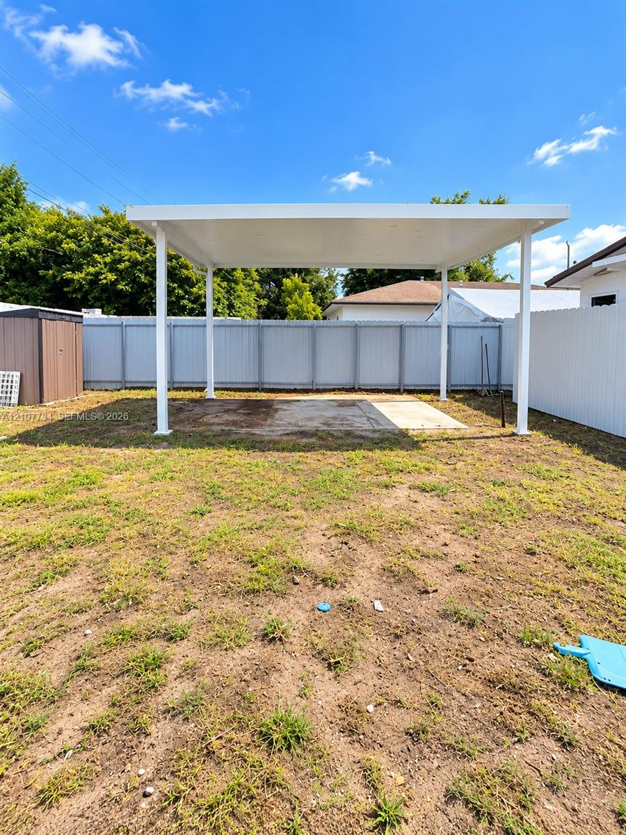 Backyard featuring a covered patio, concrete slab, and privacy fencing