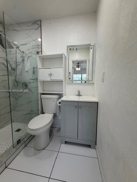 Walk-in shower with floor-to-ceiling stone-finish tile surround and hexagonal floor tile, vanity with integrated countertop, and LED-bordered wall mirror