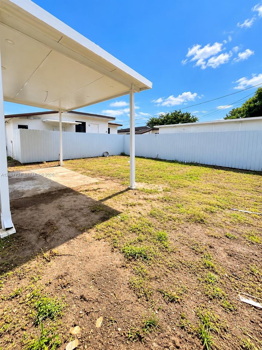 Covered concrete patio with recessed lighting and a full-perimeter white privacy fence Covered concrete patio with recessed lighting and a full-perimeter white privacy fence