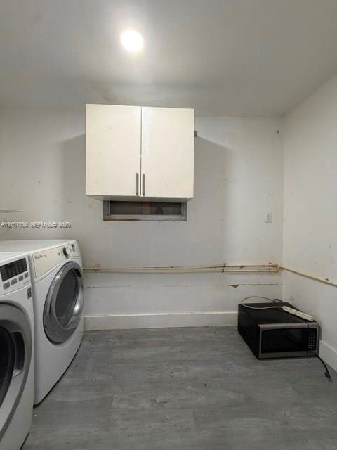 Wall-mounted white cabinetry and grey wood-finish flooring