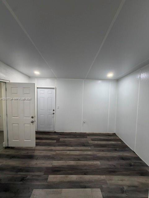 Interior room featuring wood-finish flooring, recessed lighting, and white paneled walls, with two six-panel entry doors