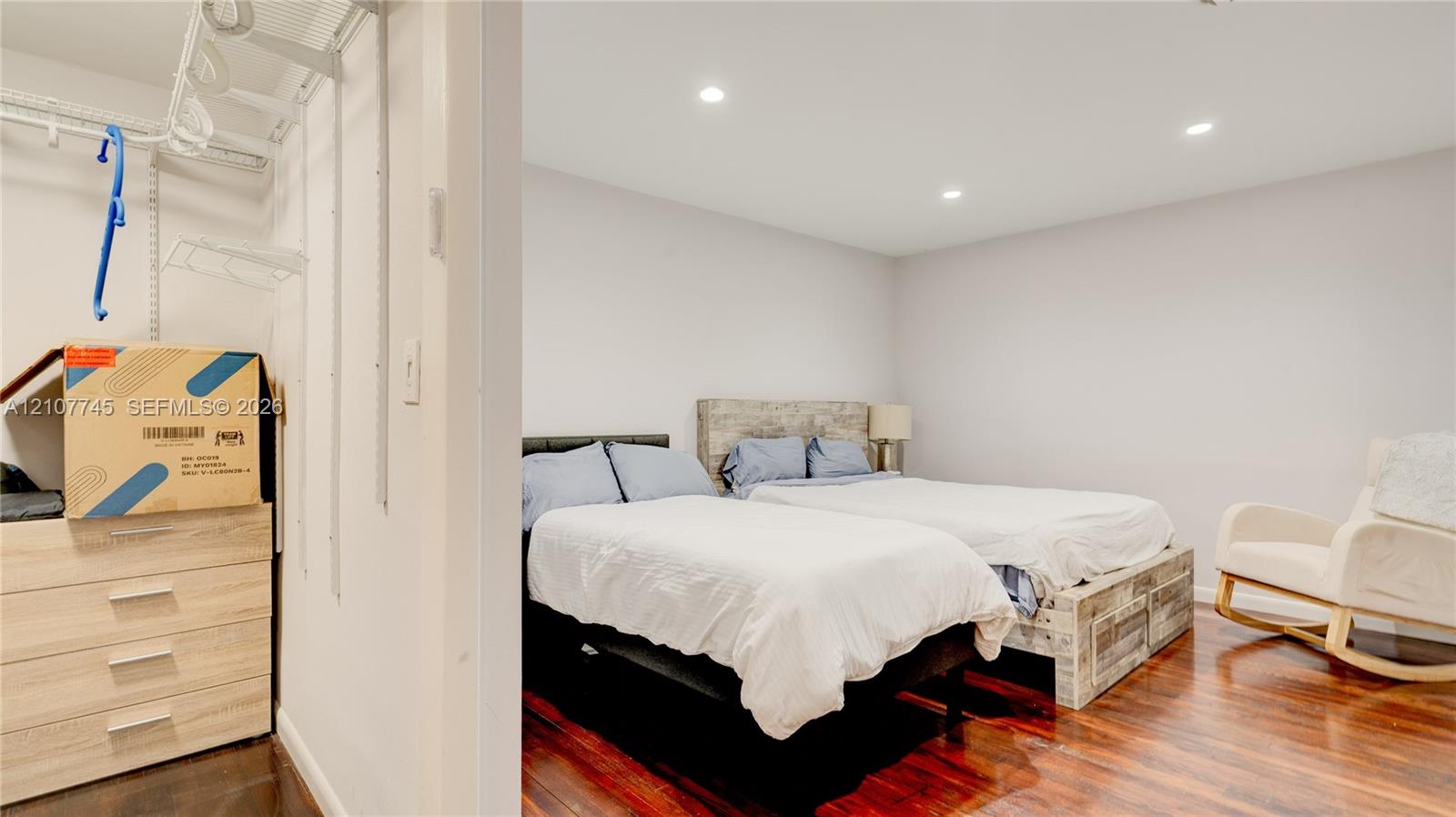 Room featuring wood-finish flooring, recessed lighting, and a walk-in closet with integrated wire shelving