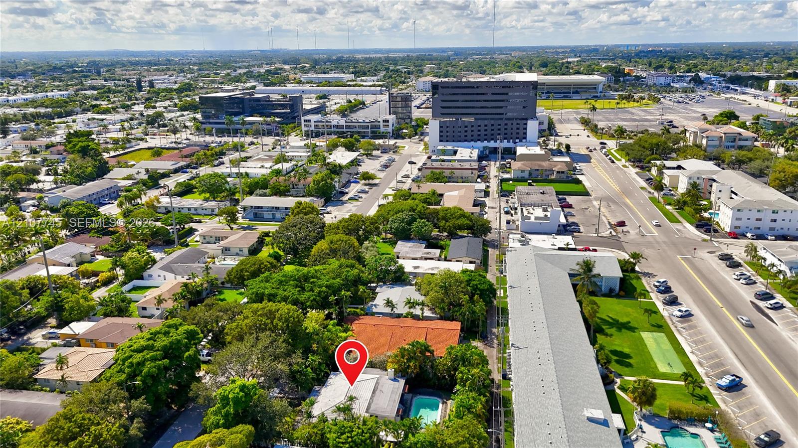 Aerial perspective featuring a residential property with a tile roof, an in-ground swimming pool, and mature perimeter landscaping