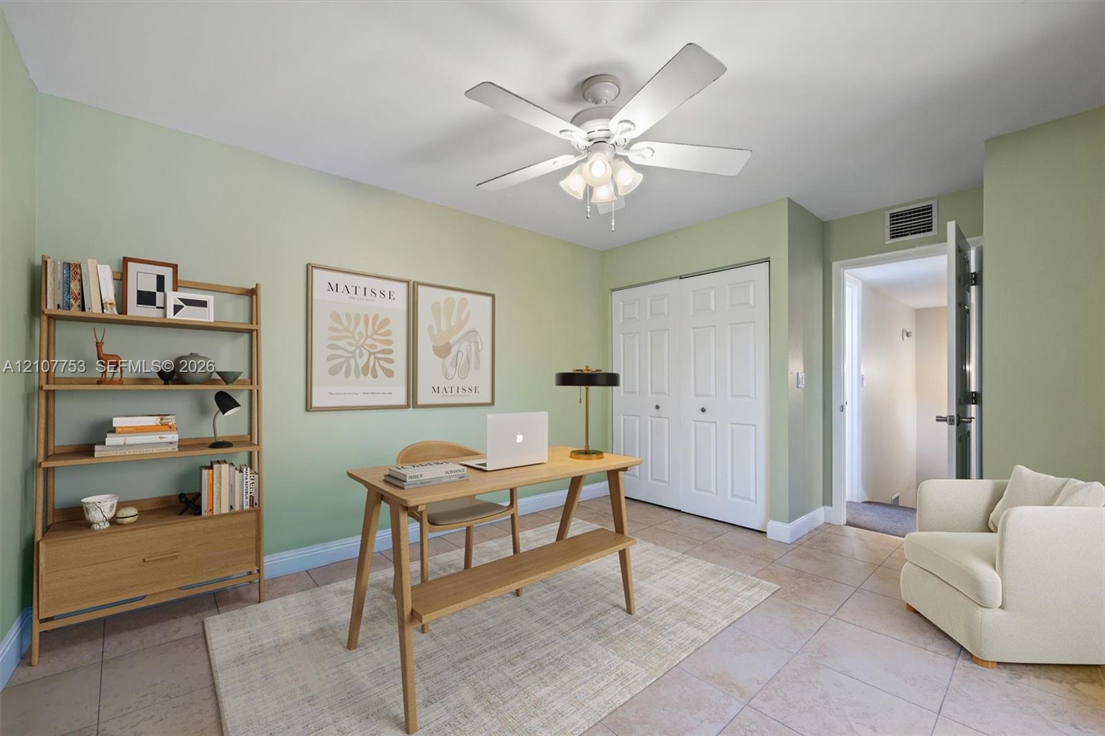 Room featuring tile flooring, a central ceiling fan with integrated lighting, and a double-door closet