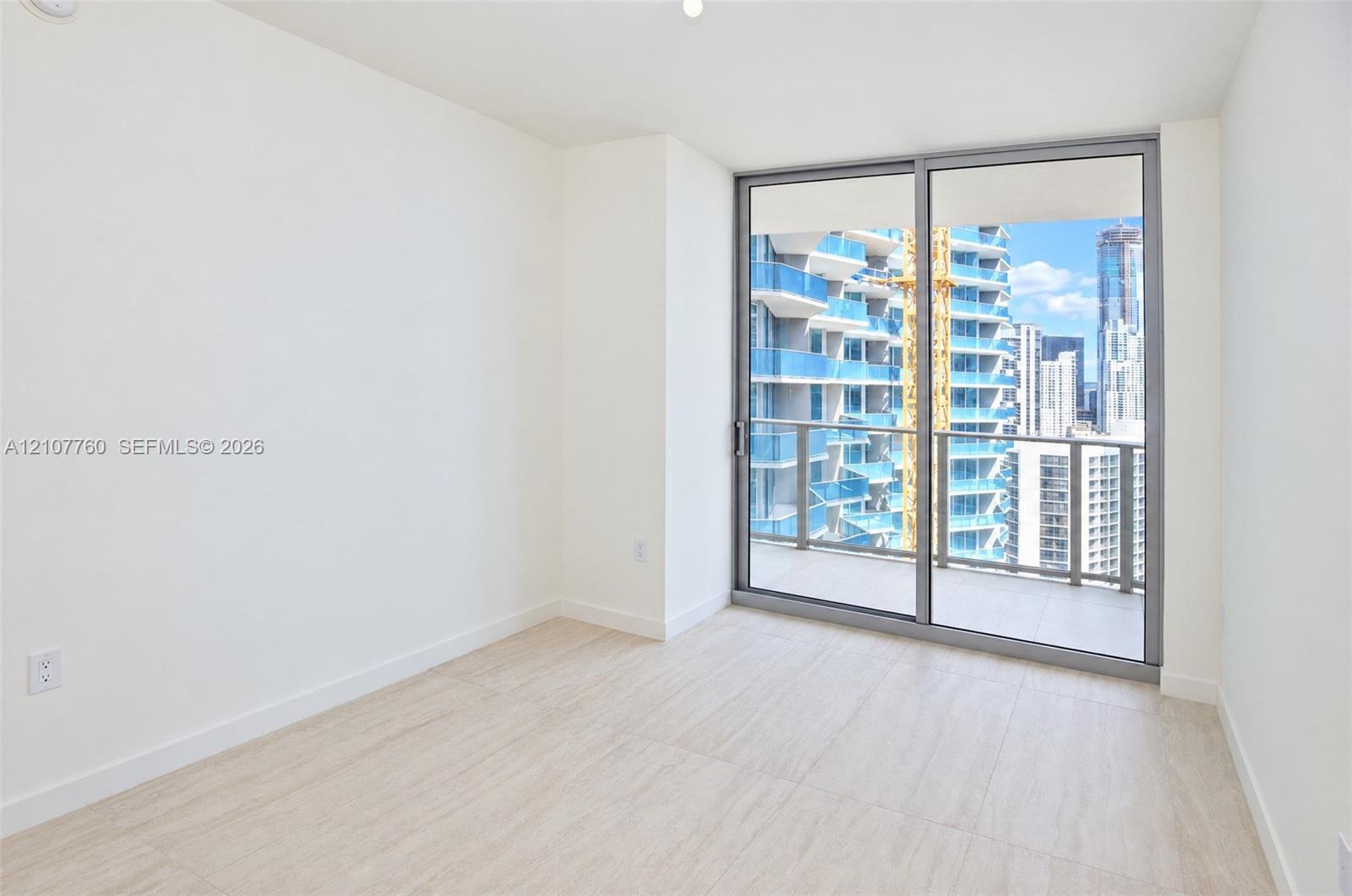 Interior space featuring wood-finish flooring, floor-to-ceiling sliding glass doors, and a private balcony