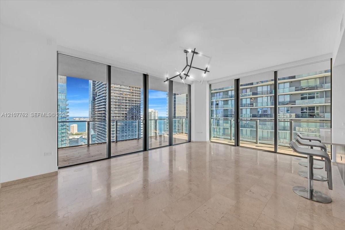 Floor-to-ceiling windows, wrap-around balcony, polished stone flooring, and architectural geometric chandelier Floor-to-ceiling windows, wrap-around balcony, polished stone flooring, and architectural geometric chandelier