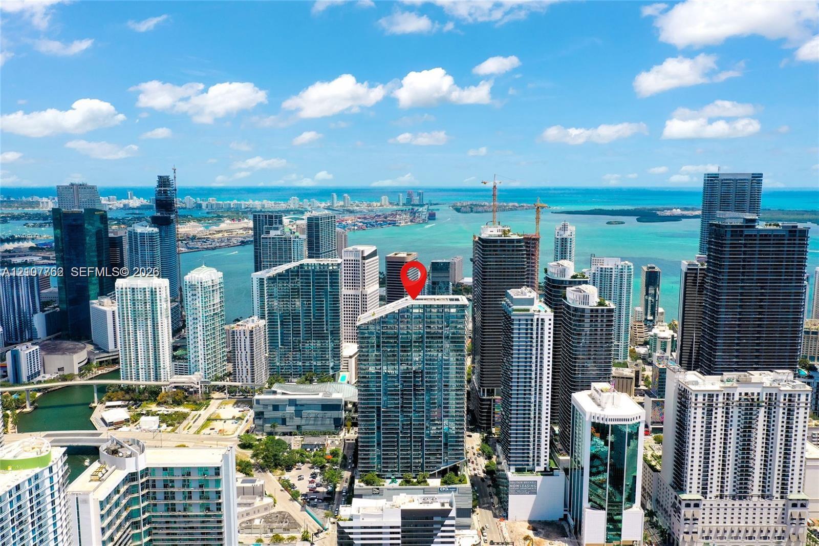 Aerial perspective of a high-rise tower featuring a glass-facade exterior and a prominent downtown urban skyline orientation Aerial perspective of a high-rise tower featuring a glass-facade exterior and a prominent downtown urban skyline orientation