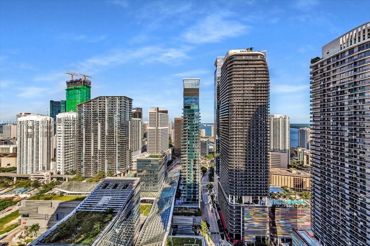 High-rise urban landscape featuring architectural glass-facade skyscrapers, concrete high-density development, and a water backdrop