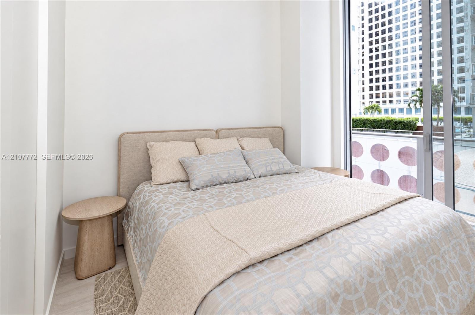 Floor-to-ceiling sliding glass door, neutral interior walls, and light-toned wood-finish flooring Floor-to-ceiling sliding glass door, neutral interior walls, and light-toned wood-finish flooring