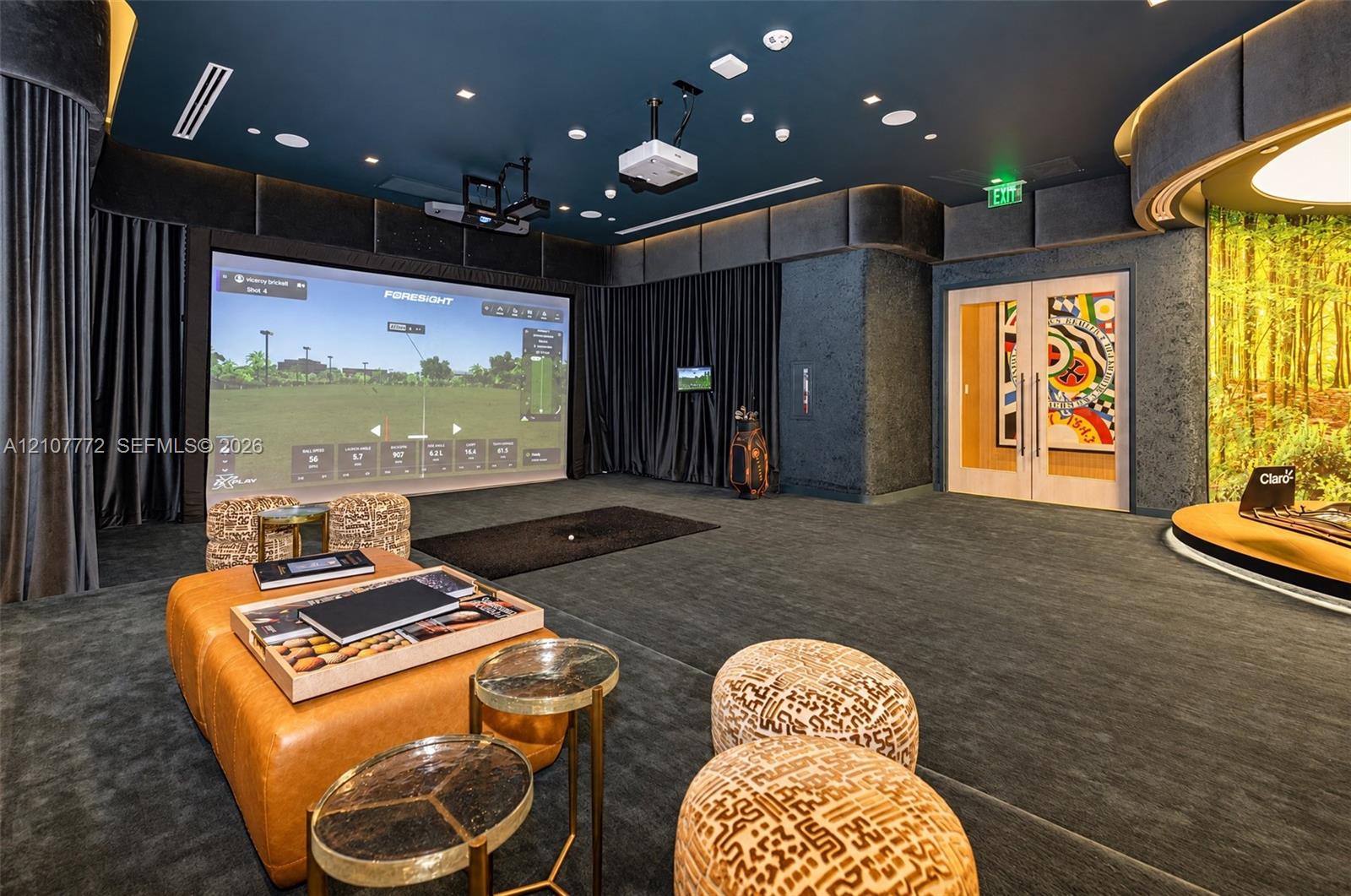 Dedicated recreation room featuring a built-in golf simulator, integrated projection system, recessed cove lighting, and floor-to-ceiling drapery