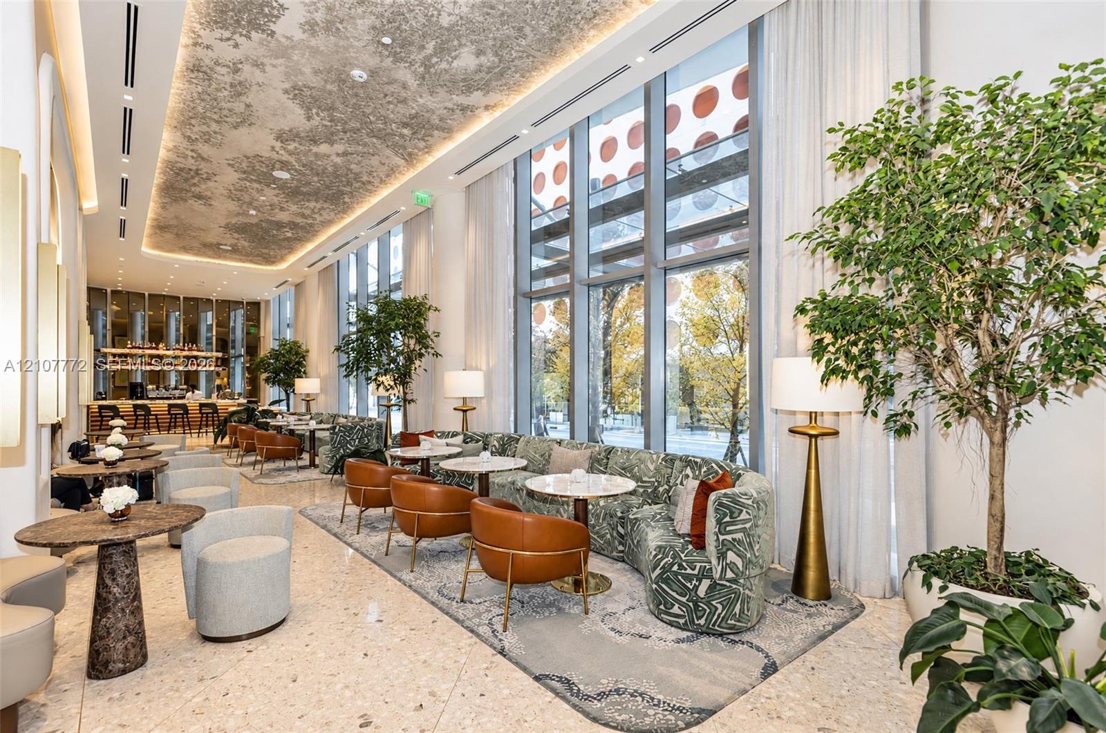 Double-height floor-to-ceiling windows, polished stone flooring, intricate decorative ceiling plasterwork, and recessed cove lighting Double-height floor-to-ceiling windows, polished stone flooring, intricate decorative ceiling plasterwork, and recessed cove lighting