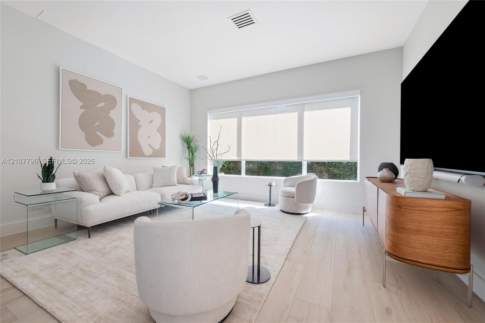 Light-filled interior featuring expansive picture windows, neutral walls, and light wood-finish flooring