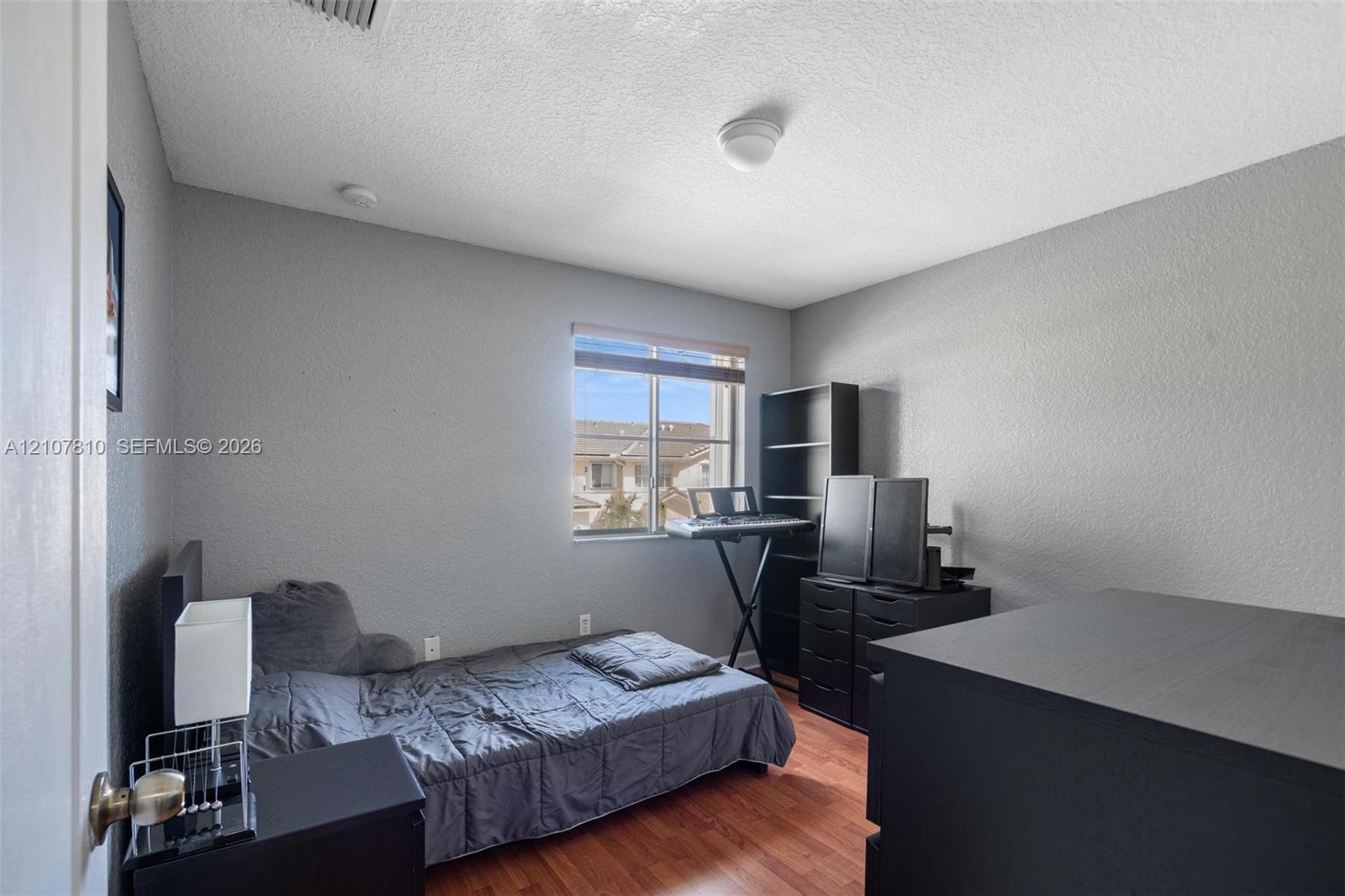 Interior space featuring wood-finish flooring, neutral-toned walls, and a single-pane window
