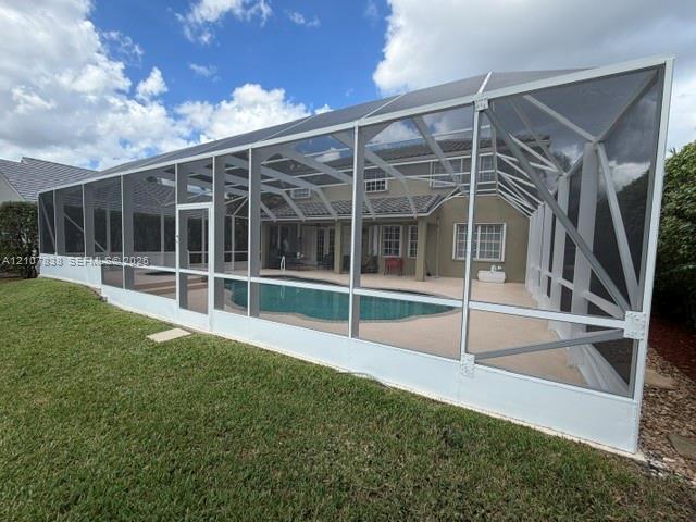 Screen-enclosed patio featuring a swimming pool, concrete pool deck, and integrated spa
