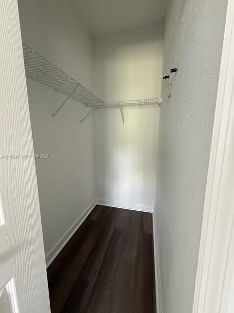 Storage space featuring white wire shelving and wood-finish flooring
