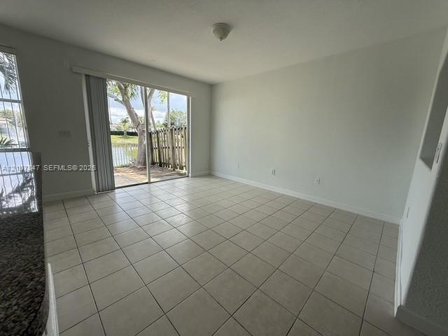 Ceramic tile flooring, sliding glass door with exterior access, stone-finish countertop, and built-in wall niche Ceramic tile flooring, sliding glass door with exterior access, stone-finish countertop, and built-in wall niche