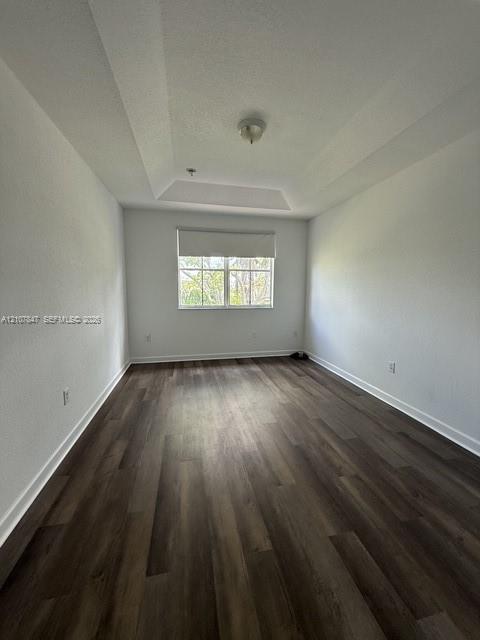 Tray ceiling, wood-finish flooring, and single-pane window with roller shade
