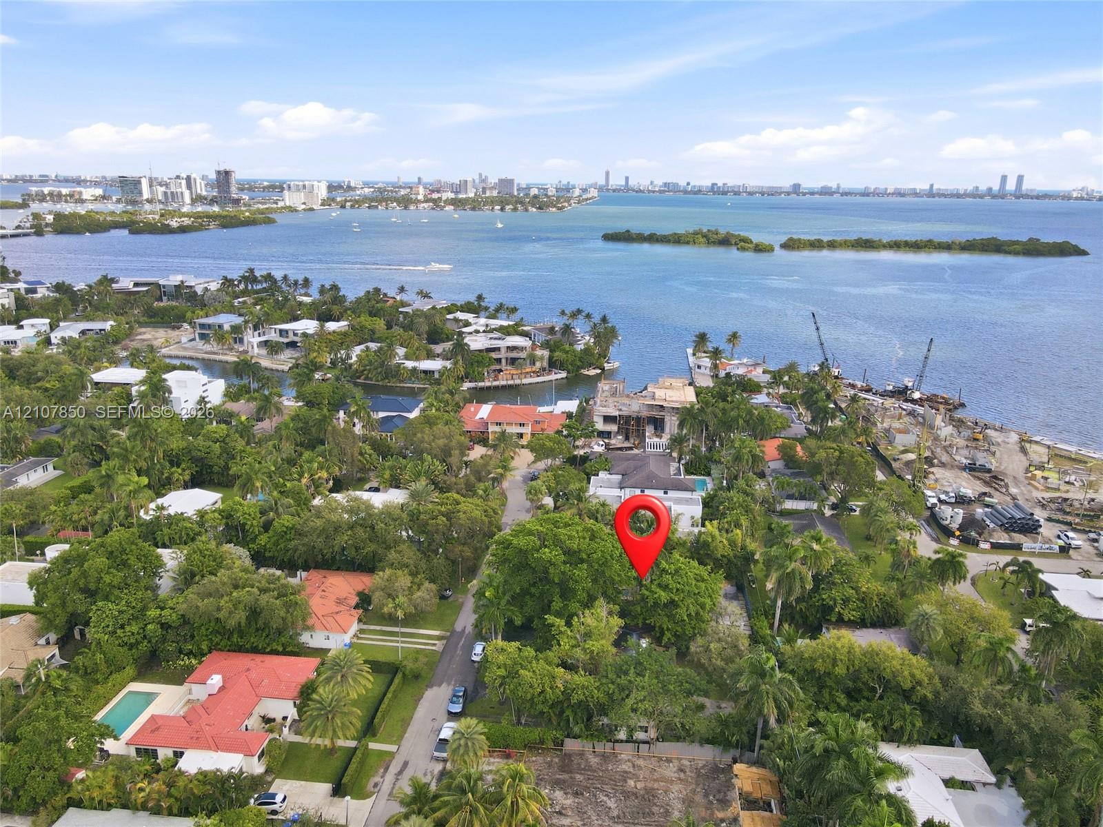 Aerial perspective of a coastal parcel featuring mature canopy trees, waterfront proximity, and established neighborhood foliage