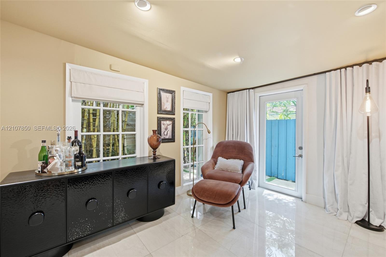 Polished tile flooring, recessed lighting, multi-pane windows with Roman shades, and a glass-paneled exterior door