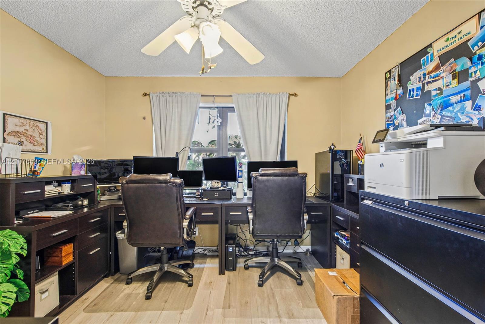 Room featuring a ceiling-mounted light fixture with a central fan and wood-finish flooring