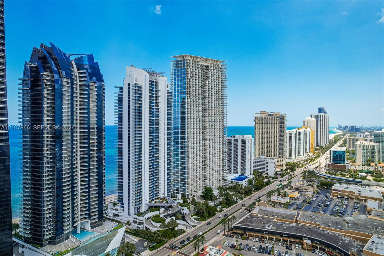 High-rise residential architecture featuring glass facades, multiple cantilevered balconies, and a coastal skyline setting