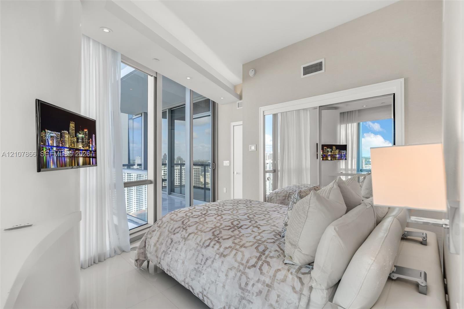 Floor-to-ceiling glass windows, recessed ceiling lighting, sliding glass door, and mirrored closet doors