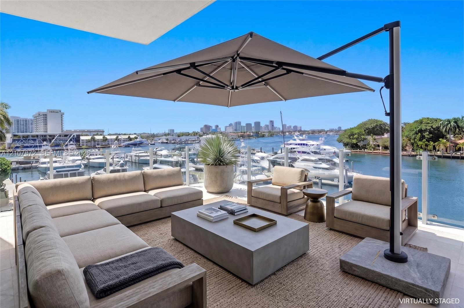 Expansive outdoor terrace featuring light-toned stone tile flooring and a glass panel railing