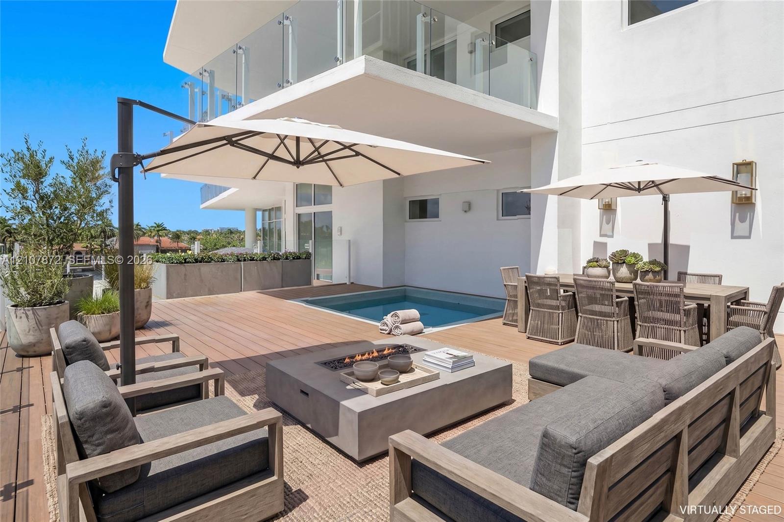 Expansive deck featuring wood-finish flooring, built-in plunge pool, and elevated glass-panel balcony railing