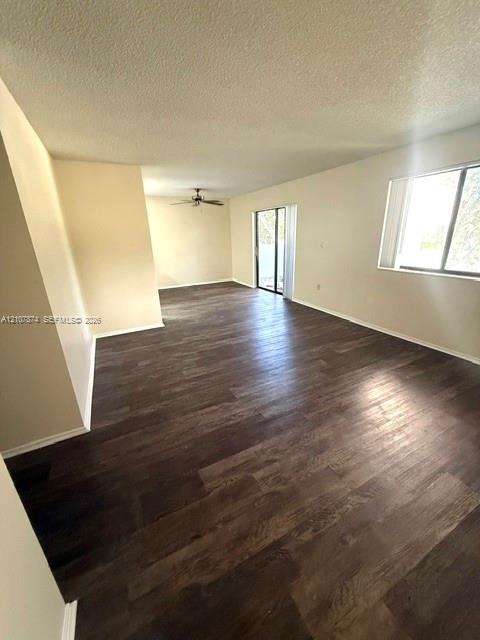Open-concept living space featuring wood-finish flooring, a ceiling fan, and sliding glass doors