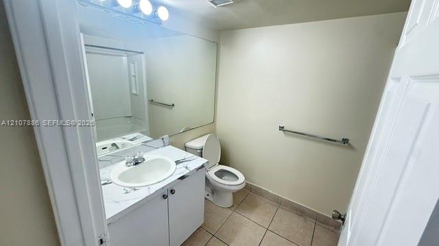 Bathroom featuring a vanity with a white-veined countertop, integrated oval basin, full-width vanity mirror, tile flooring, and metallic towel bars