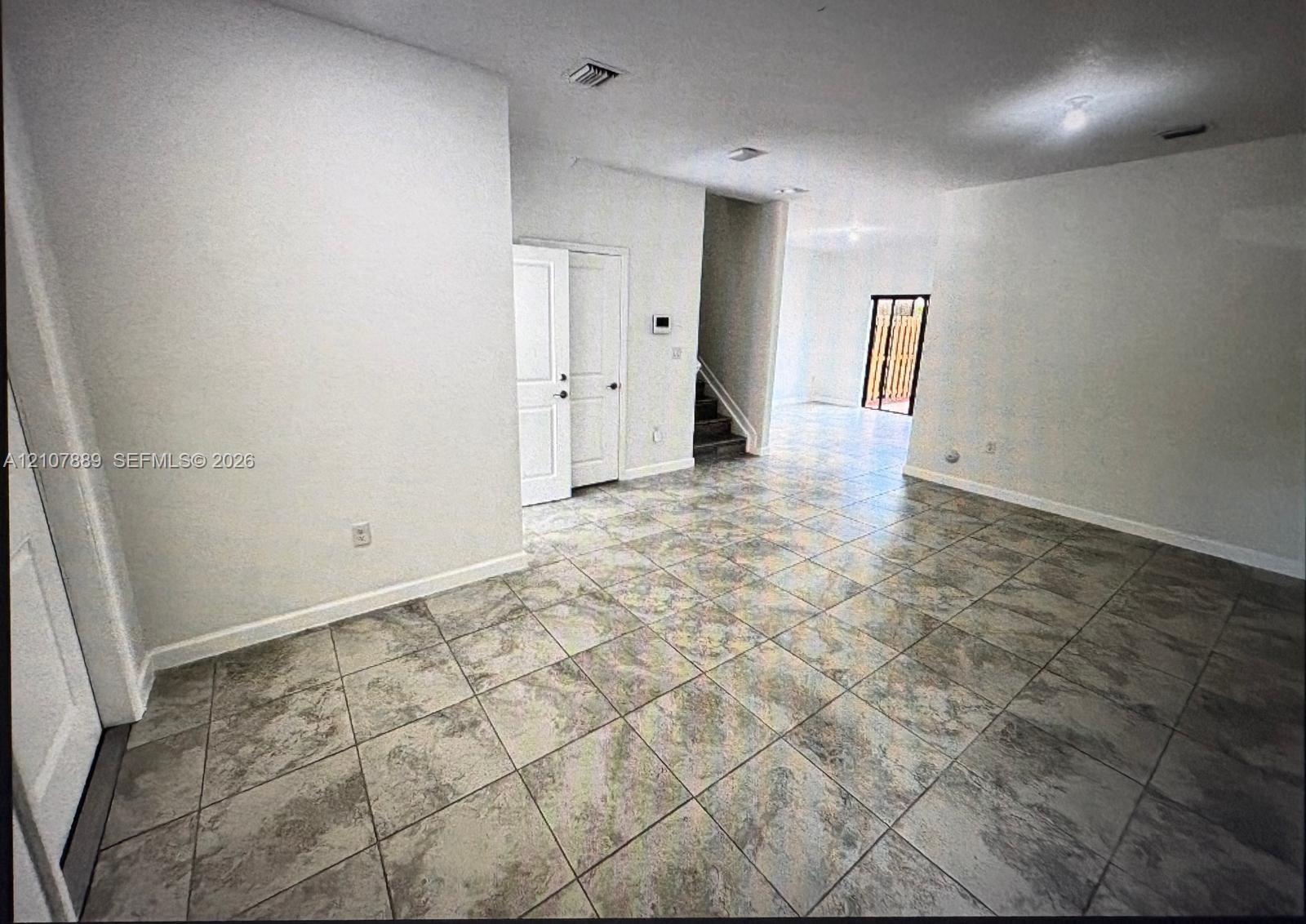 Interior space featuring large-format stone-patterned tile flooring, neutral wall finish, recessed lighting, and interior paneled doors