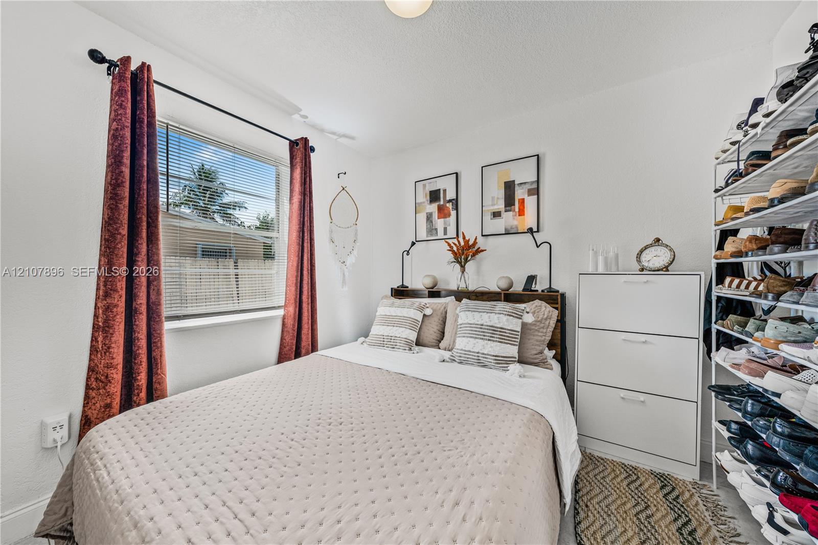 Bedroom featuring a horizontal window and installed white metal shelving
